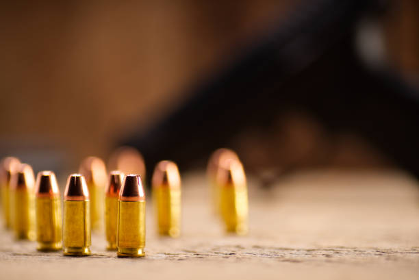 Closeup images of 9mm Luger or 9mm Parabellum handgun ammunition on old wood.