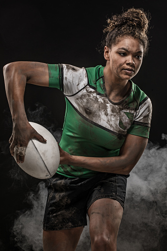 A female Rugby Players covered in mud and dirt in a studio shot