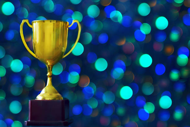 istock Winner hold trophy with abstract bokeh light background 1173601562