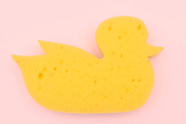 Yellow duck sponge on a pink background. view from above. baby bath sponge. Yellow duck sponge on a pink background. view from above. baby sponge. sponge bath sponge nature animal stock pictures, royalty-free photos & images