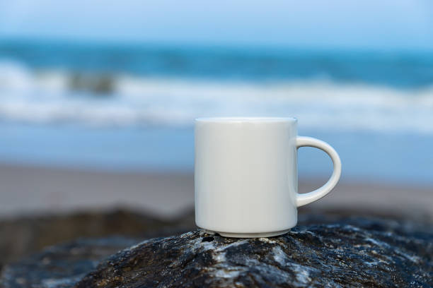 istock White coffee cup on the rock at sea. 1173605393