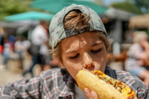istock Cute teenage boy eating hot dog 1173605865