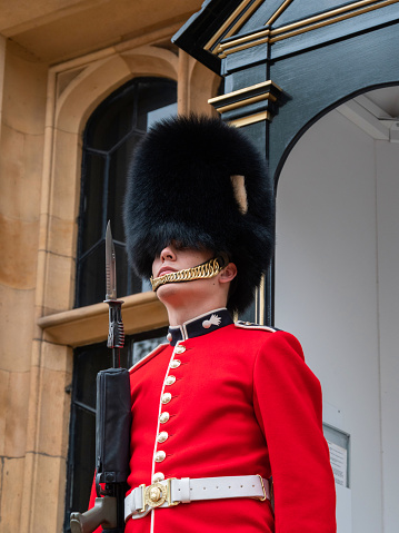 London, UK - April, 2019: Royal guard of London at a post near the Tower of London, close-up portrait, view from bottom. Soldier of the Royal Guard of London. Queen's Guard on duty at Tower of London.