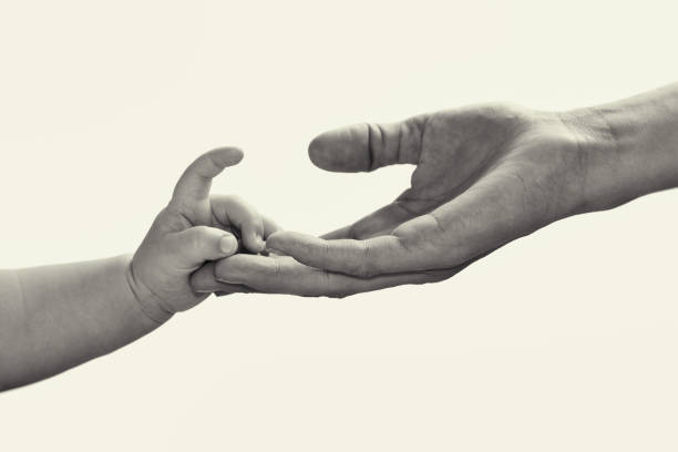 A close up of a newborn baby gripping his dad's finger. Newborn is eight days old.