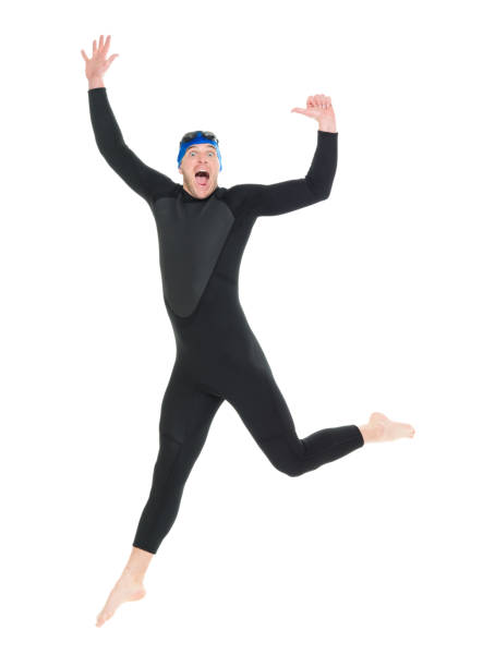 full length / one man only / side view / profile view of 30-39 years old handsome people caucasian male / mid adult men / mid adult triathlete doing triathlon / swimming / jumping / mid-air in front of white background who is joy / excited - swimming male isolated swimming goggles imagens e fotografias de stock