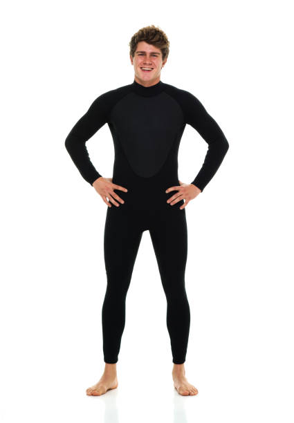 One man only / full length of 20-29 years old adult handsome people caucasian male / young men standing in front of white background wearing wetsuit / swimwear who is excited / happy / smiling / successful / shouting and celebration who is barefoot with hand on hip / surfing / thank you - phrase un hombre sólo / longitud completa de 20-29 años de edad adulto guapo personas caucásicas hombres / hombres jóvenes de pie frente a fondo blanco usando traje de neopreno / traje de baño que está emocionado / feliz / sonriente / exitoso / gritando y c