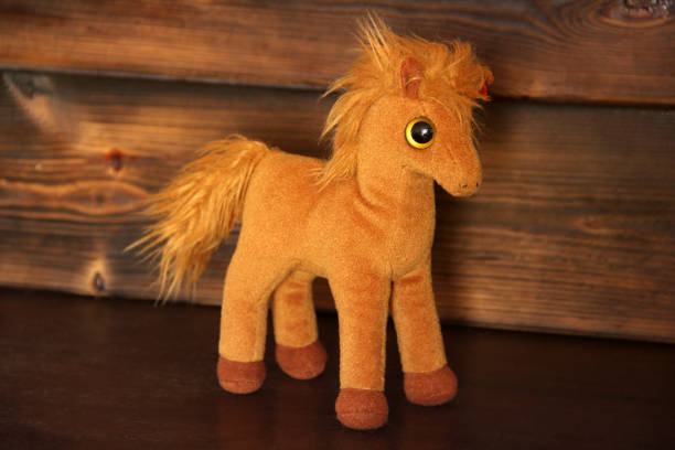 istock Soft toy on wooden background. Horse 1173618287