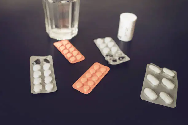 glass of water and pills against disease