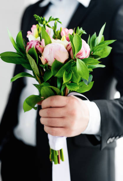 istock A man holding wedding rose bouquet in hand 1173622707