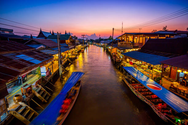 vista do mercado flutuante de amphawa cidades e turistas andam de compras, comer e tirar fotos ao redor da área. há muitos restaurantes na área. é um dos mercados flutuantes mais populares na tailândia - indigenous culture famous place thailand bangkok - fotografias e filmes do acervo