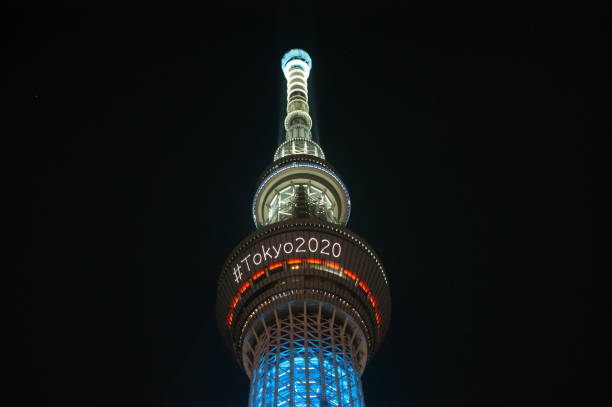 la tour skytree est illuminée la nuit annonçant les jeux olympiques de tokyo 2020 avec un hashtag. - tokyo prefecture tokyo tower night skyline photos et images de collection