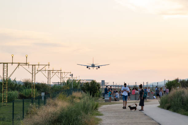エルプラットバルセロナ空港に着陸する航空機は、人々のグループをオーバーフライング - ils ストックフォトと画像