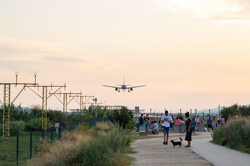 Aircraft landing in El Prat Barcelona airport overflying a group of people