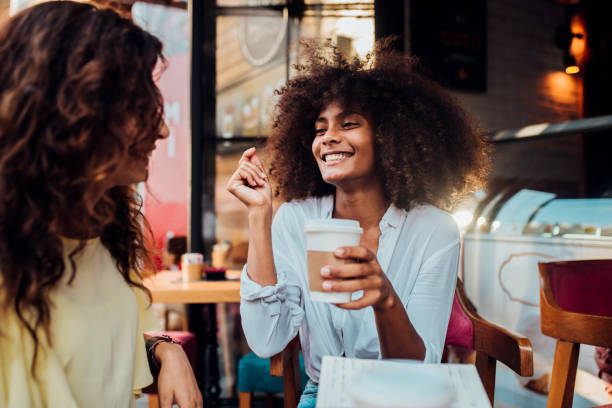 istock Young girl drinking coffee with her friend 1173625858