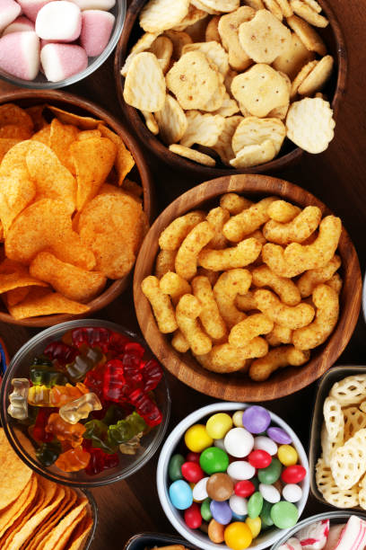 istock Salty snacks. Pretzels, chips, crackers and candy sweets on table 1173627492