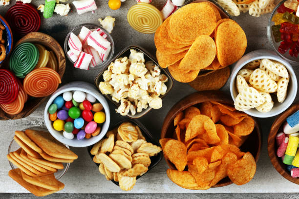 istock Salty snacks. Pretzels, chips, crackers and candy sweets on table 1173627626