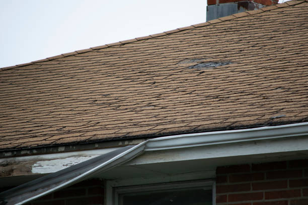 istock Damaged and old roofing shingles and gutter system on a house 1173628378