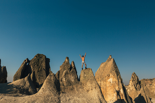 Man with arms outstretched on mountaintop