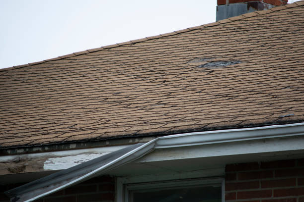 istock Damaged and old roofing shingles and gutter system on a house 1173628464