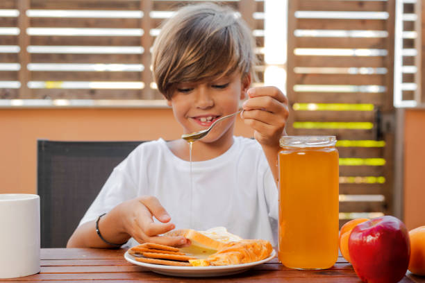 istock Child delivers honey on bread 1173634744