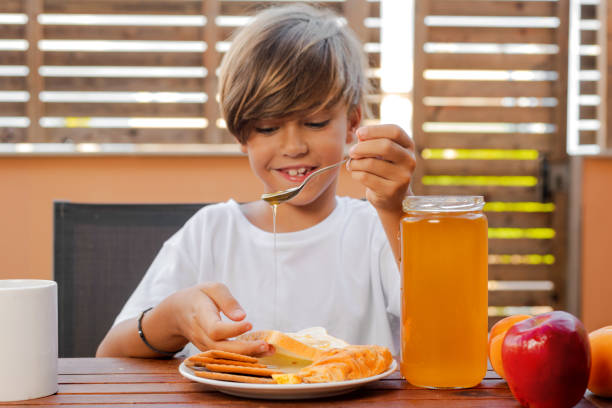 Child delivers honey on bread stock photo