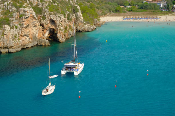 istock View on on the beach Cala en Porter with white boats, Menorca. 1173637680