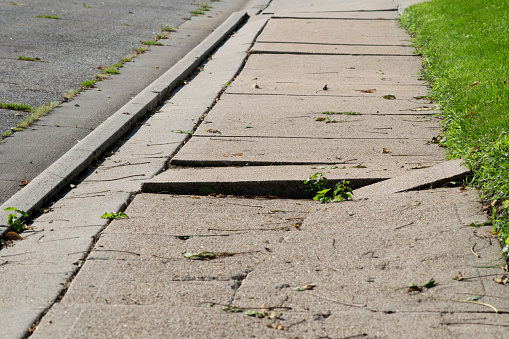 Uneven damaged sidewalk, tripping hazard