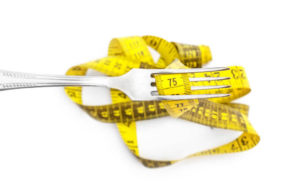 istock Measure tape on fork. Isolated on white. Top view. 1173639677