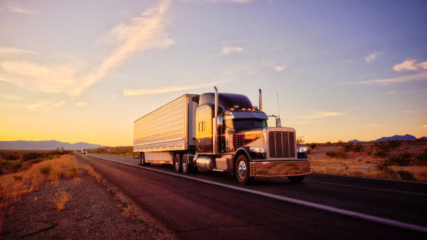 Long Haul Semi Truck On a Rural Western USA Interstate Highway Large semi truck hauling freight on the open highway in the western USA under an evening sky. starlitetrucking stock pictures, royalty-free photos & images
