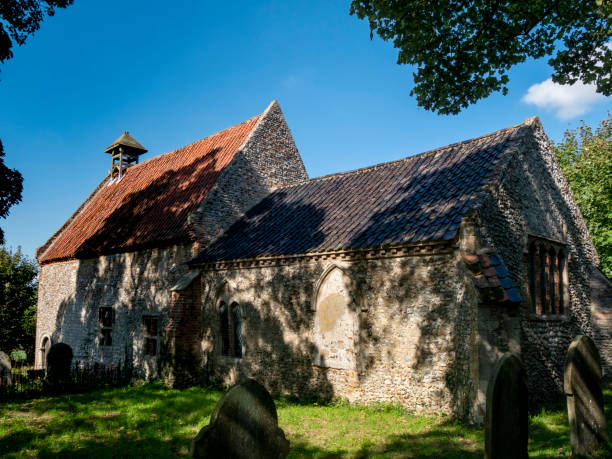 Church of All Saints, Waterden, Norfolk Part of the exterior of All Saints Church, Waterden, in Norfolk, Eastern England. All Saints is of Anglo-Saxon origin, has some interesting Norman features and is hard to find, deep in rural Norfolk. norman uk tree sunlight stock pictures, royalty-free photos & images