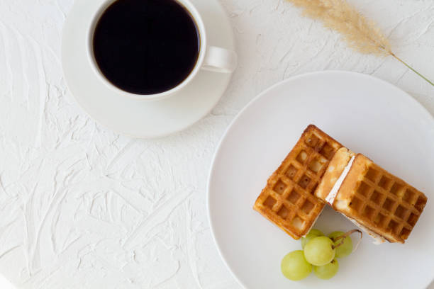 istock breakfast with cup of coffee and Belgian waffles on white background top view. 1173643697