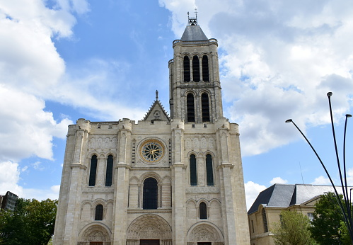 Paris, France. View of the Basilique Saint-Denis, the first gothic church. Facade and tower with clouds.
