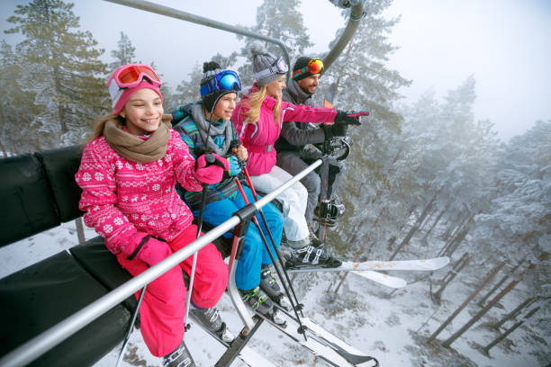 istock family enjoying winter vacations in mountains and making selfie 1173648636