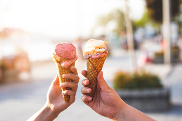 gelato in paio di mani - cono foto e immagini stock