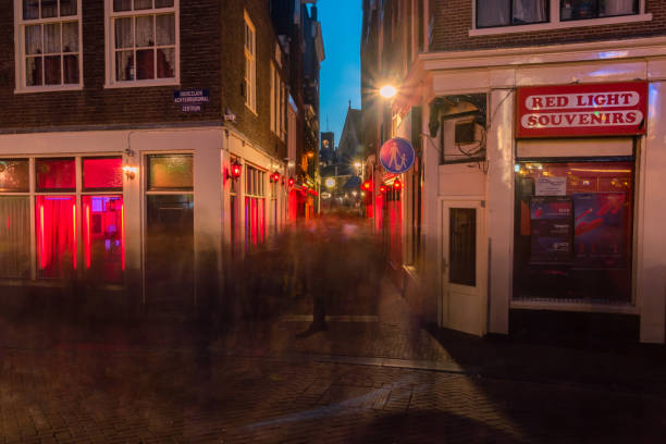 Long exposure photo with blurred people in De Wallen, Amsterdam's red-light district at night, one of the main tourist attractions. Amsterdam, Netherlands-June 6, 2019: Long exposure photo with blurred people in De Wallen, Amsterdam's red-light district at night, one of the main tourist attractions. wellen stock pictures, royalty-free photos & images