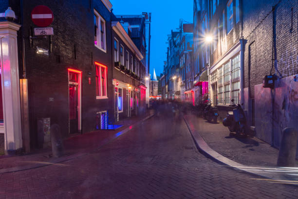 Red Light District with Red and blue lights windows. In De Wallen women sex workers user red lights in windows, while transsexual women sex workers use blue lights Amsterdam, Netherlands-June 6, 2019: Red Light District with Red and blue lights windows. In De Wallen women sex workers user red lights in windows, while transsexual women sex workers use blue lights wellen stock pictures, royalty-free photos & images