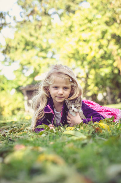 istock child and cat relaxing on grass 1173656848
