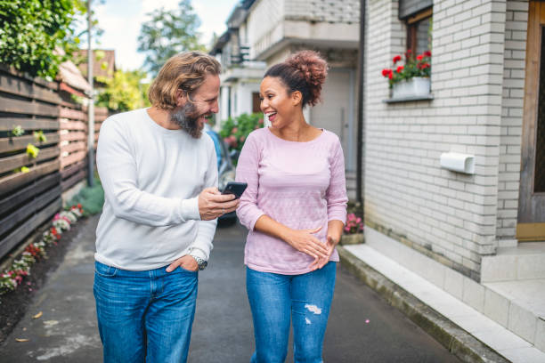 istock Multi Ethnic Couple Using Smart Phone and Walking Down the Street 1173656914