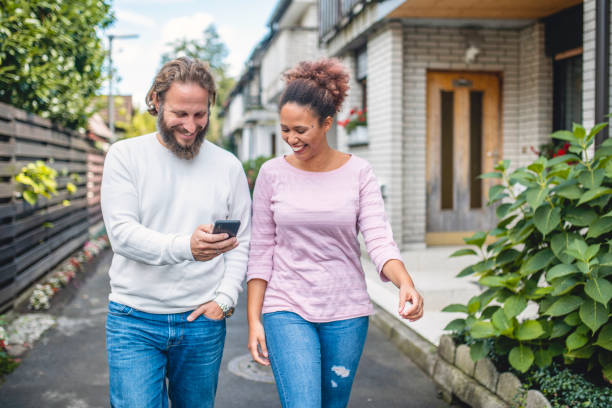 istock Multi Ethnic Couple Using Smart Phone and Walking Down the Street 1173656928