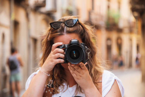 istock Young woman using a DSLR camera in a city 1173657704