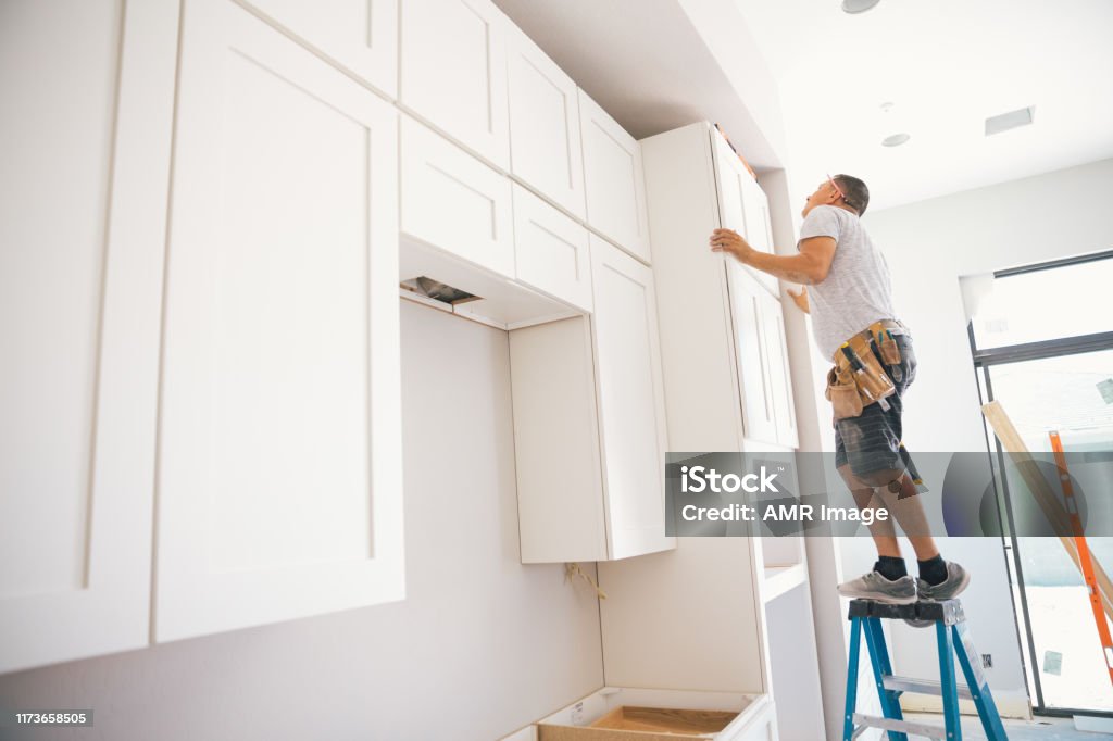 Fitting a kitchen Installing a kitchen in a new house. Cabinet Stock Photo
