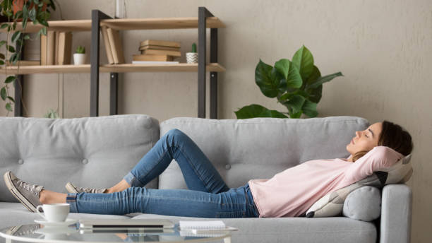 istock Tired young woman relax at home sleeping on cozy couch 1173666047