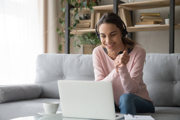 istock Smiling woman watching webinar sitting on couch at home 1173666083