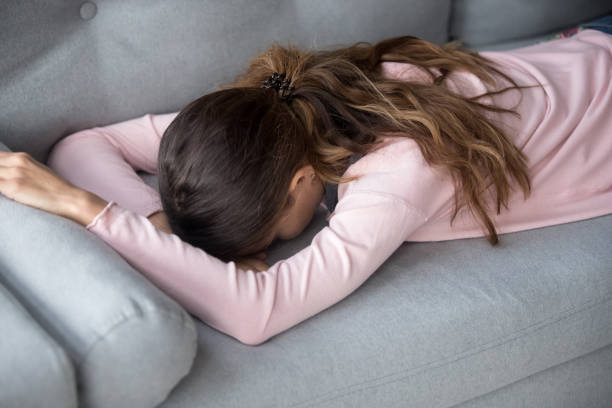 istock Upset girl lying on sofa at home lacking motivation 1173666118