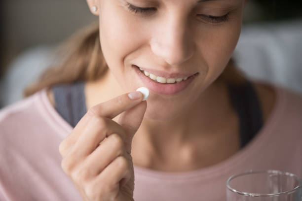 istock Smiling young woman having vitamins at home 1173666121