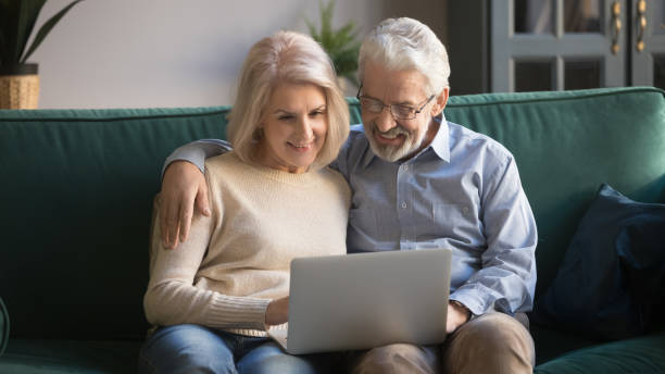 istock Happy old senior couple using laptop sit on sofa 1173666467