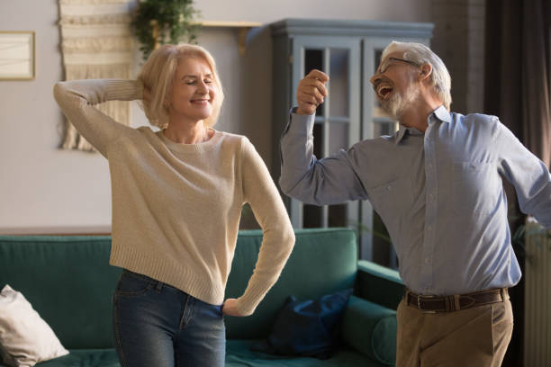 istock Happy active retired elder couple dancing together in living room 1173667003