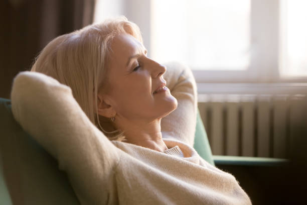 istock Happy lazy old woman relaxing meditating leaning on comfortable sofa 1173667026