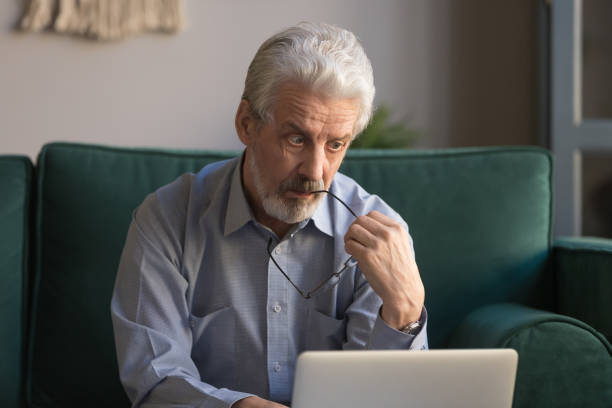 istock Puzzled serious thoughtful mature senior man looking at laptop screen 1173667067