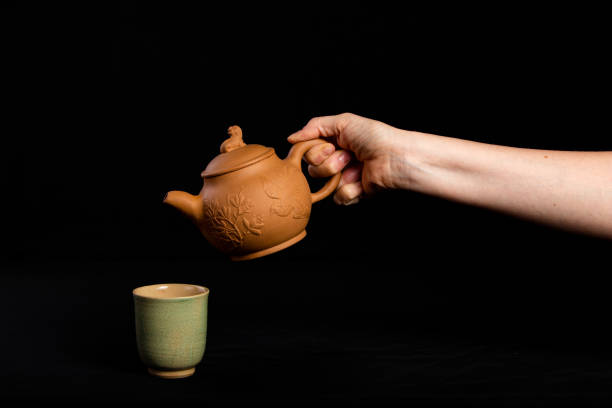 istock A tea pot ready to pour tea into a tea cup 1173671254